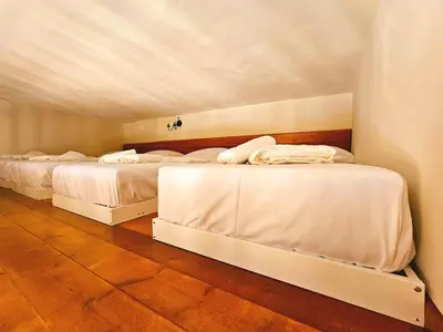 two beds in a room with white sheets at BROWN ON GREEN a stone house with amazing view in Drapaniás
