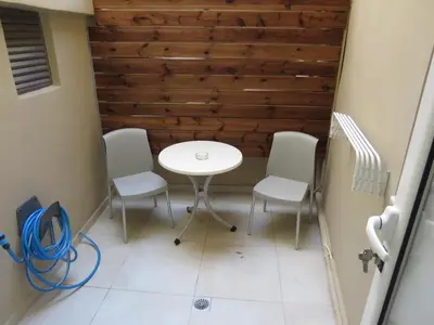 a table and chairs in a room with a wall at Cosy apartment in Koum Kapi Beach in Chania Town