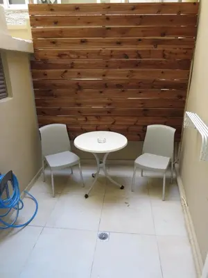 a table and chairs in a room with a wooden wall at Cosy apartment in Koum Kapi Beach in Chania Town