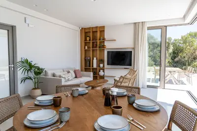 a living room with a table and chairs and a television at Ataraxia Villa in Spiliá
