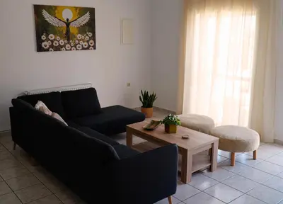 a living room with a couch and a coffee table at IKARUS apartment with courtyard & pool in Chania in Stérnai