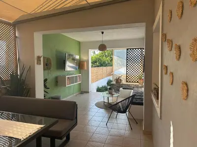 a living room with green walls and a table at Vila Alexandros in Souda