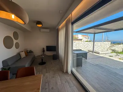 a living room with a couch and a sliding glass door at Gialos Villas Paleochora in Palaiochóra