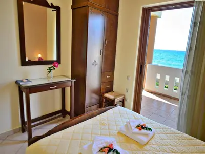 a bedroom with a bed and a mirror and a window at Niriides Apartments in Kissamos