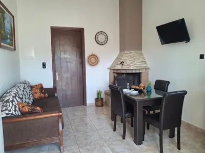 a living room with a table and a fireplace at Casa Ioanna - Elegant Residence in Kalivianí