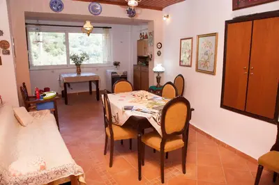 a kitchen and dining room with a table and chairs at Villa Olea-Renieri in Grigorianá