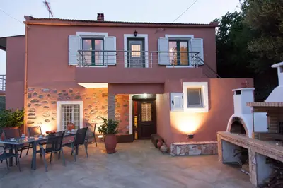 a house with a table and chairs in front of it at Villa Olea-Renieri in Grigorianá