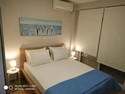 a bedroom with a white bed and a blue blanket at Evan's place in Chorafakia