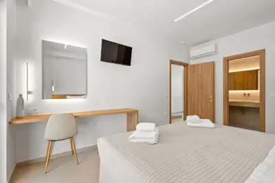 a white room with a bed and a chair at Sea Princessa Villa in Chania Town