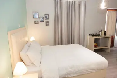 a bedroom with a bed with white sheets and pillows at Shalom Luxury Rooms Kondilaki in Chania Town