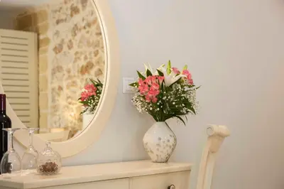 a vase of flowers sitting on a shelf in front of a mirror at Shalom Luxury Rooms Kondilaki in Chania Town