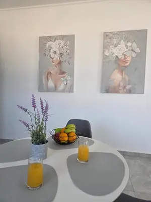 a table with two glasses of orange juice and a bowl of fruit at Olive Angel 1 in Chania Town