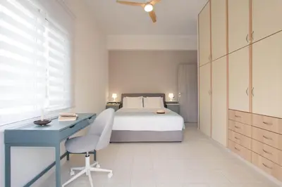 a bedroom with a bed and a desk and a bed at Blue Haven Chania Apt in Chania Town