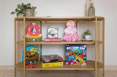 a wooden shelf with toys and games on it at Blue Haven Chania Apt in Chania Town