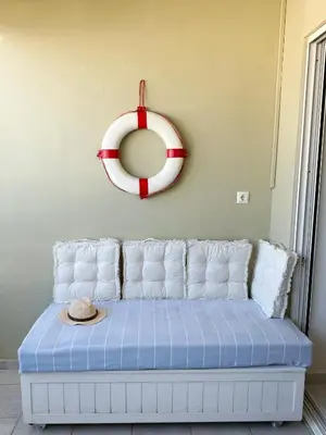 a room with a couch with a mirror and a hat at Chania Memories Apartment in Chania Town