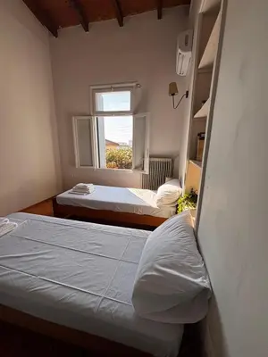 two beds in a room with a window at Yellowstone Chania in Chania Town
