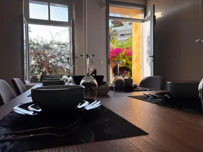 a dining room table with chairs and a large window at Yellowstone Chania in Chania Town