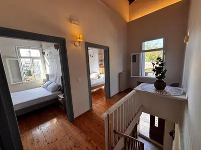 a small room with a bed and two windows at Yellowstone Chania in Chania Town