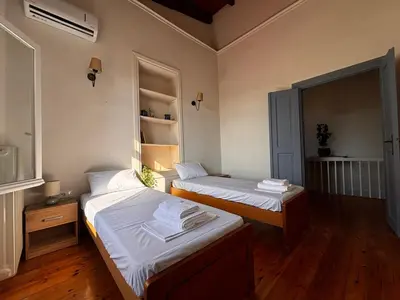 two beds in a room with wooden floors at Yellowstone Chania in Chania Town
