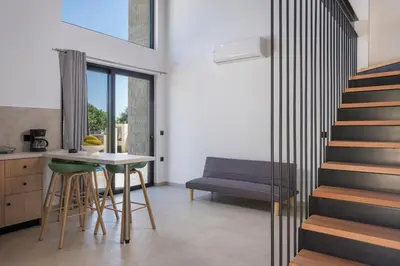 a living room with a staircase and a table at NEA Dreamy Houses in Agia Marina Nea Kydonias