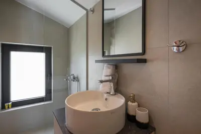a bathroom with a sink and a mirror at NEA Dreamy Houses in Agia Marina Nea Kydonias