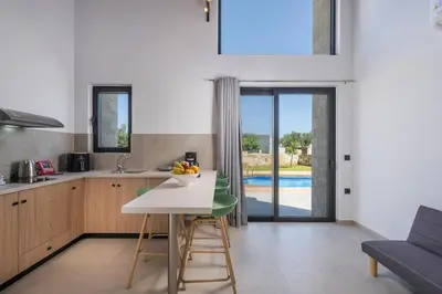 a kitchen with a table and a dining room at NEA Dreamy Houses in Agia Marina Nea Kydonias