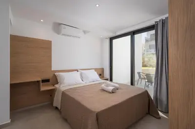 a bedroom with a bed and a large window at NEA Dreamy Houses in Agia Marina Nea Kydonias