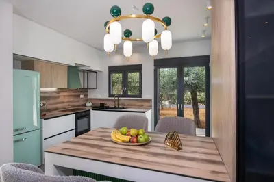 a kitchen with a bowl of fruit on a wooden table at Glafkos house with pool near the beach in Daratso