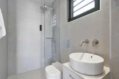 a white bathroom with a sink and a shower at Villa Meraki in Stalos