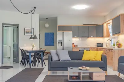 a living room and kitchen with a couch and a table at Sylvie Comfort Living in Chania Town
