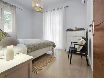 a bedroom with a bed and a desk and a chair at Dafne Almyrida Beach Apartment in Almirida