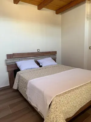a bedroom with two beds with white walls and wooden floors at Stay near Balos & the seaside in Kaloudhianá