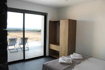 a bedroom with a bed and a sliding glass door at Astrokastro Frangokastello in Frangokastello
