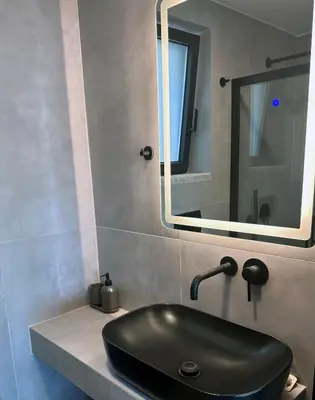 a bathroom with a black sink and a mirror at Astrokastro Frangokastello in Frangokastello