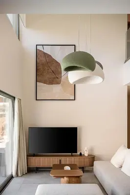 a living room with a television and a green lamp at Aurea Beach Villa in Kato Daratso