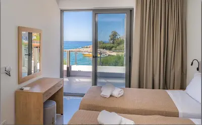 a bedroom with two beds and a view of the ocean at Phoenix Coastal Heaven in Loutro