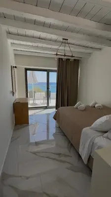 a bedroom with a bed and a view of the ocean at Phoenix Coastal Heaven in Loutro