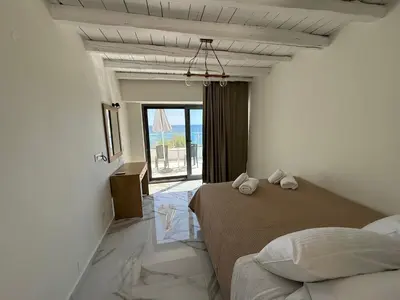 a bedroom with a bed and a large window at Phoenix Coastal Heaven in Loutro