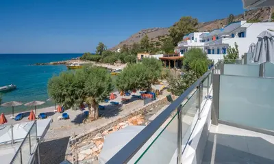 a view of the beach from the balcony of a resort at Phoenix Coastal Heaven in Loutro