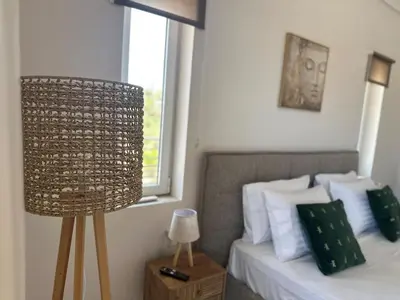 a bedroom with a bed with a window and a lamp at Casa Ansia Luxury Living 50m from the Beach in Stalos