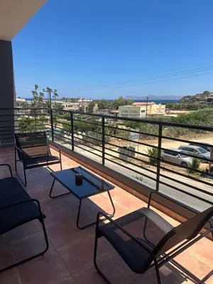 a balcony with chairs and tables and a view of the ocean at Casa Ansia Luxury Living 50m from the Beach in Stalos