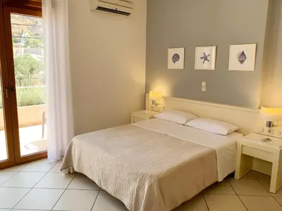 a white bedroom with a bed and a window at Platanias Memories Studio 3 in Plataniás