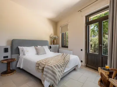 a bedroom with a bed and a large window at Armenaki Residence in Arménoi