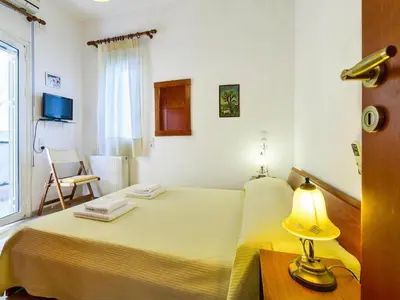 a bedroom with a bed with a lamp and a chair at Holiday home, Marathokefala near Kolimbari in Marathokefála