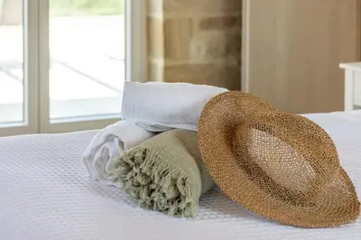 a pair of towels and hats on a bed at Villa Alma Libre Kissamos in Kissamos