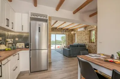a kitchen with a stainless steel refrigerator and a living room at Villa Alma Libre Kissamos in Kissamos