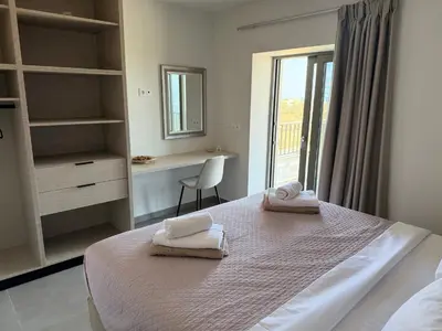 a bedroom with a bed with towels on it at Sunrise Village Aptera Private Pool Villa in Beritianá