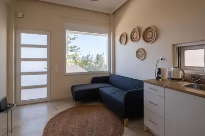 a living room with a blue couch and a sink at andys house in Chania