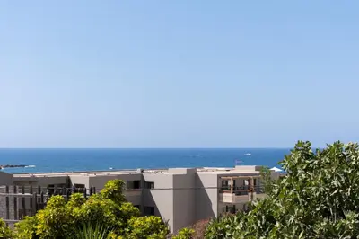 an apartment building with the ocean in the background at andys house in Chania
