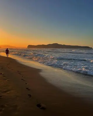a person walking on a beach with footprints in the sand at Fifty Shades of Blue 10 sec to sea 5PL 2BD 2BA in Stalos